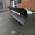  Black, curved snow plow blade mounted on a metal frame.